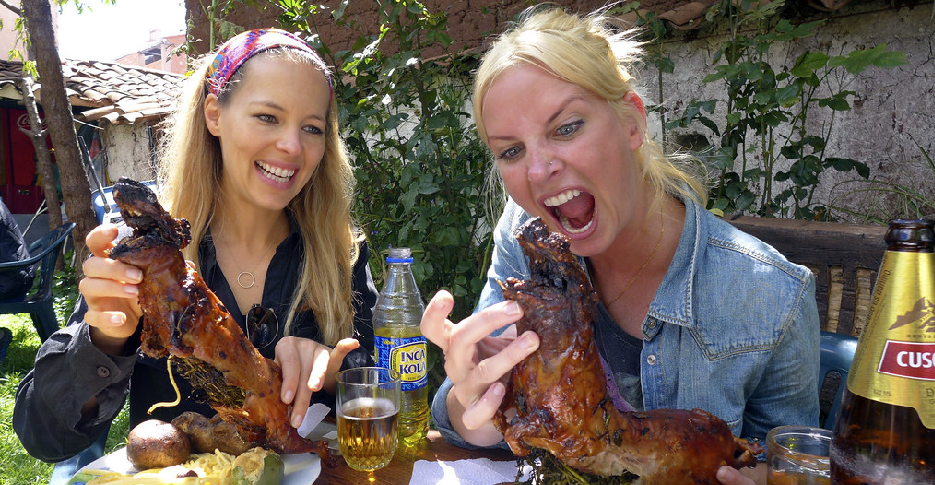 Turista probando cuy en Perú